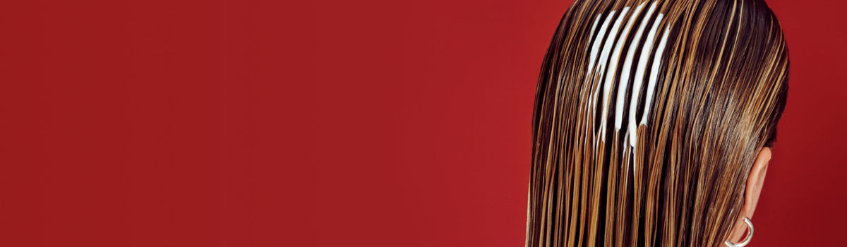 back of head image of girl with wet hair and product goop in her hair on a red background