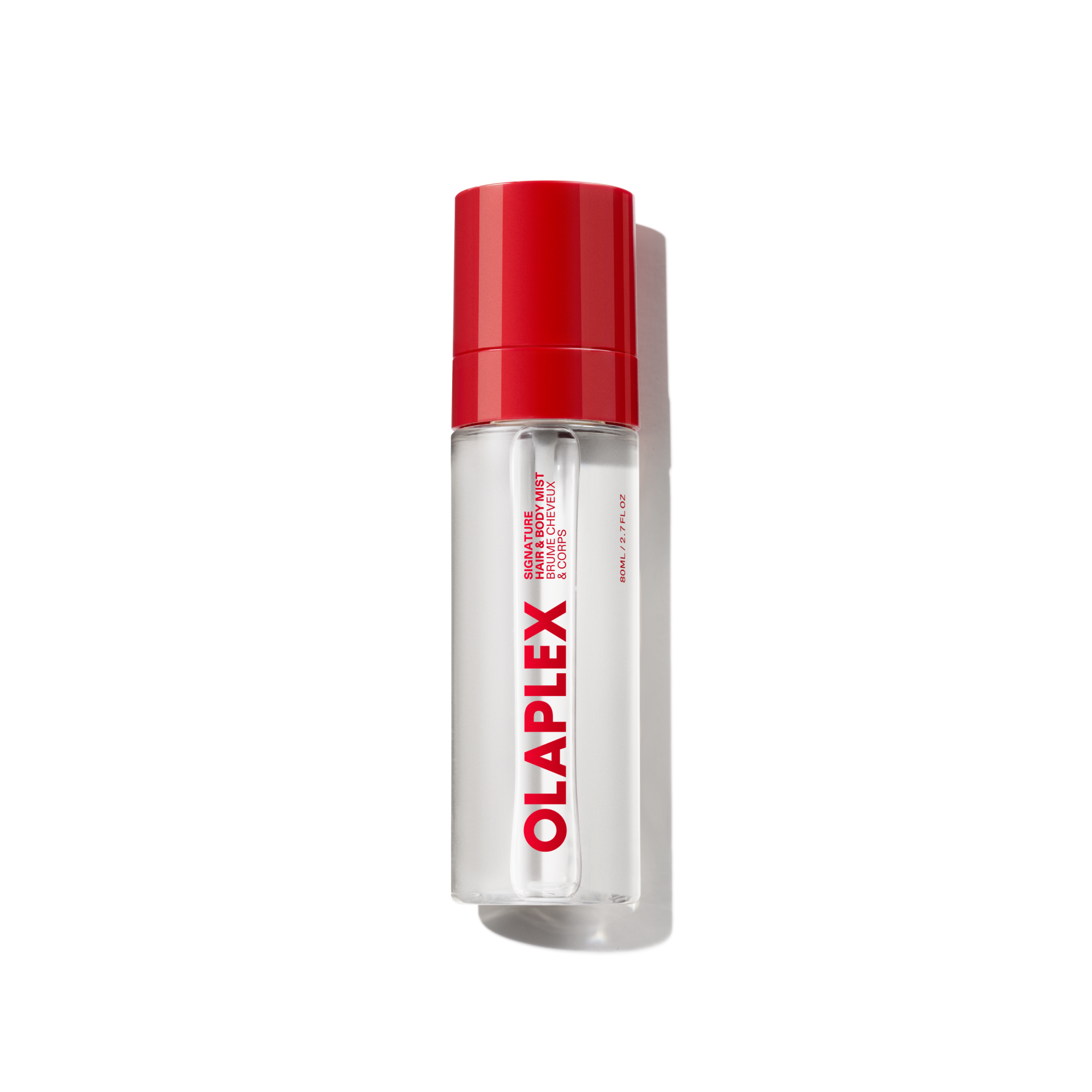 A clear bottle of Olaplex Hair and Body Fragrance Mist featuring a vibrant red cap and the bold Olaplex logo printed vertically down the front, shown against a transparent grid background.